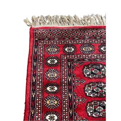 Tekke Bokhara red ground rug, decorated with two rows on Gul motifs, geometric design borders decorated with stylised floral motifs 