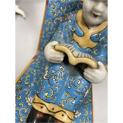 Pair of 20th century Chinese figural bookends, modelled as children in traditional blue dress sat reading and kneeling upon stacks of books, H22cm