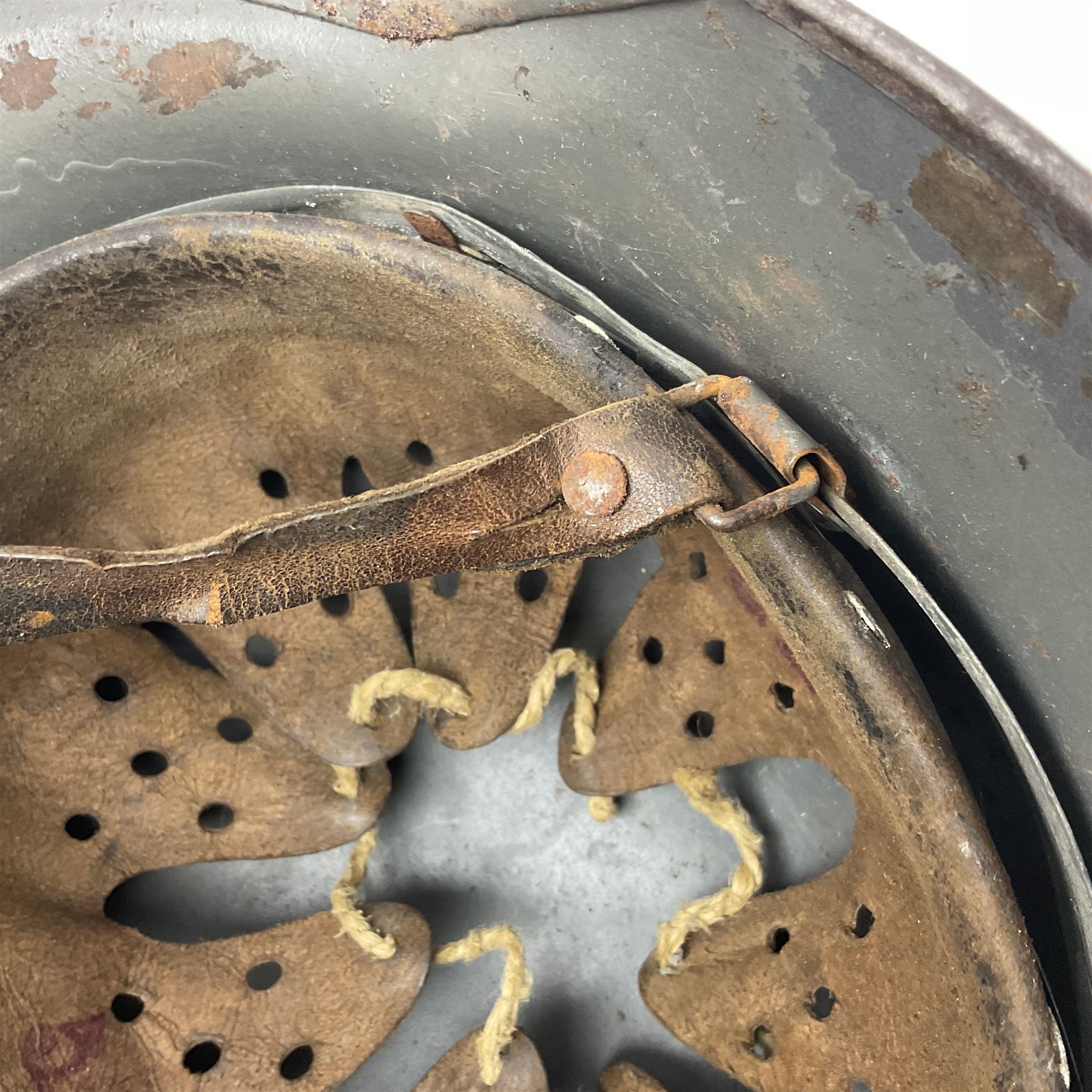WW2 German Infantry M40 steel helmet with tropical finish and traces of single decal; with chin strap and leather liner marked 57 twice in red; back apron stamped 11 38