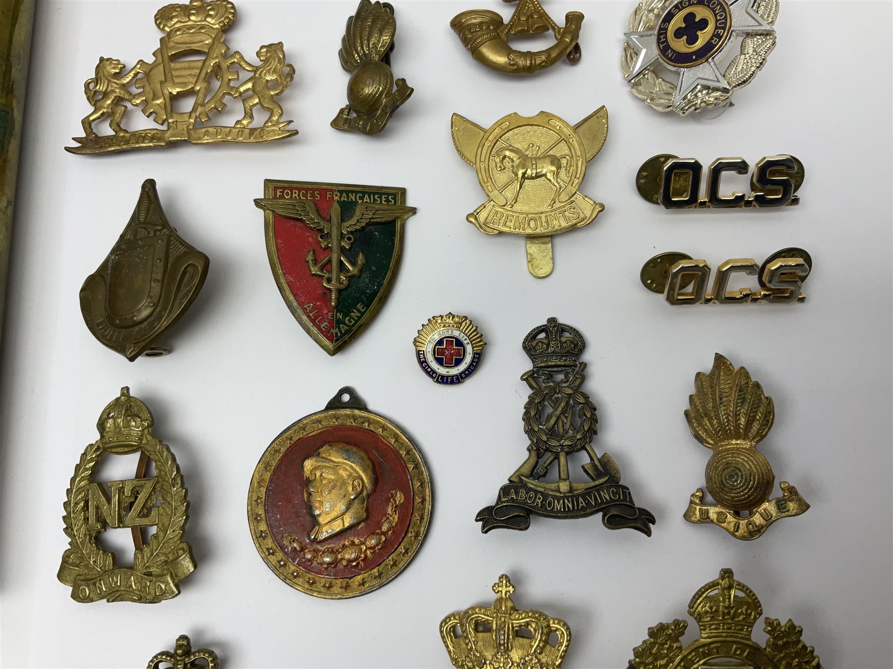 Collection of approximately sixty worldwide medals, metal badges, belt buckles, cloth badges, trench art, brass button stick etc