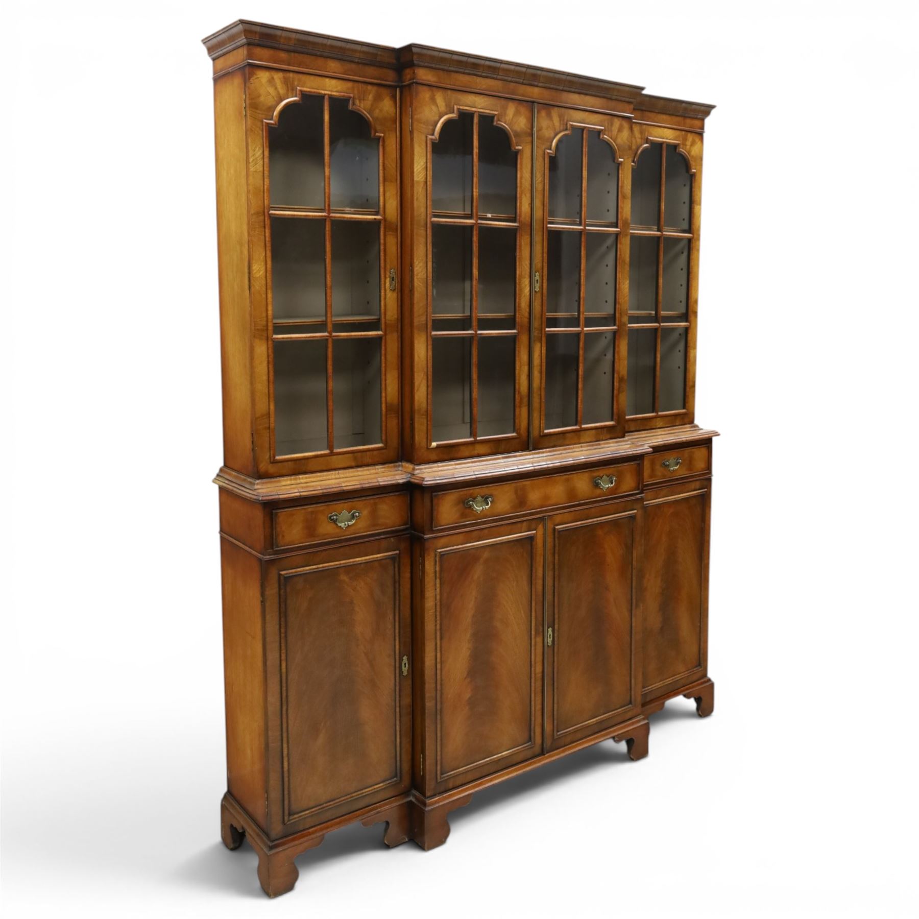 Georgian design mahogany breakfront bookcase on cupboard, projecting cornice over four arched astragal glazed doors, base fitted with three drawers over panelled cupboards, raised on bracket feet