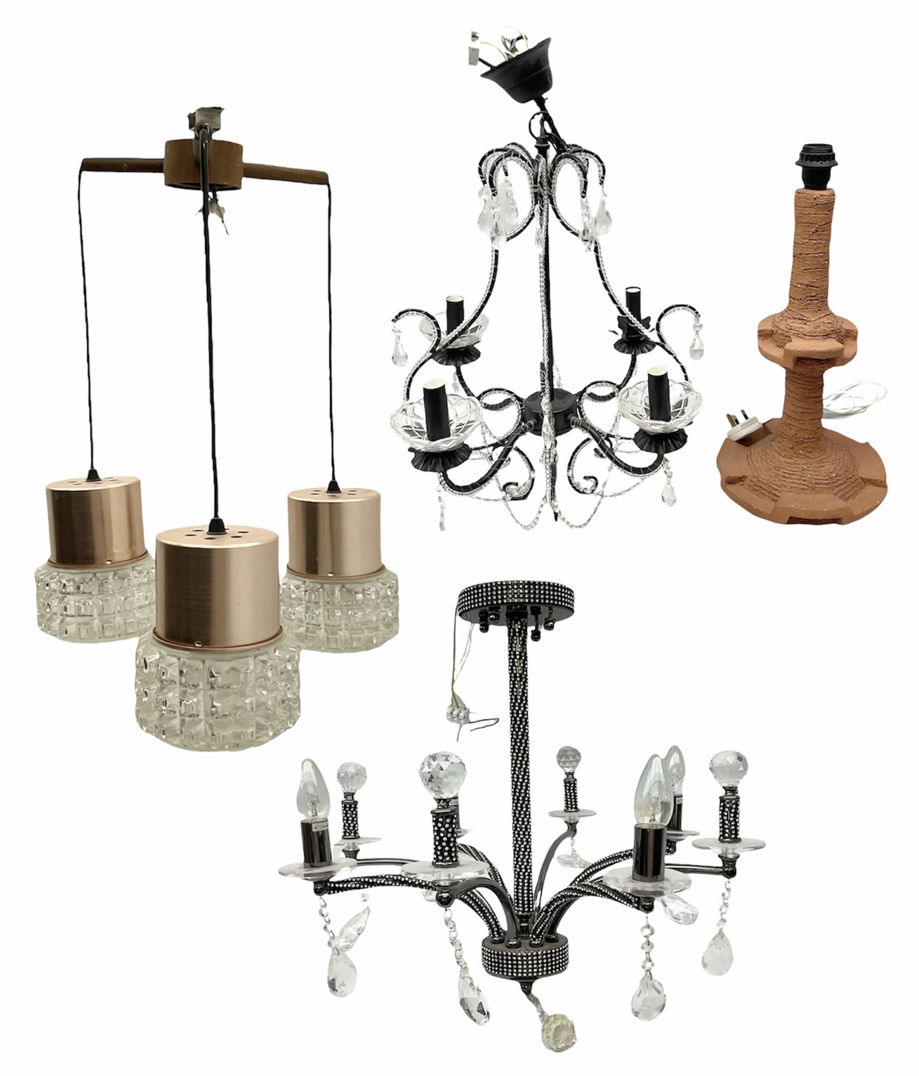 Terracotta studio pottery lamp base with carved detail and geometric knop and base, H45cm, together with a black chandelier with drops, Mid century teak light fitting with three drop down clear glass pendants and copper mounts, H54cm, and Rhinestone and black eight branched chandelier