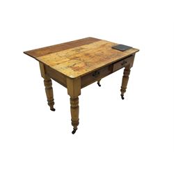 Traditional rustic pine dining table, rectangular top fitted with two drawers, raised on turned tapering supports on ceramic castors