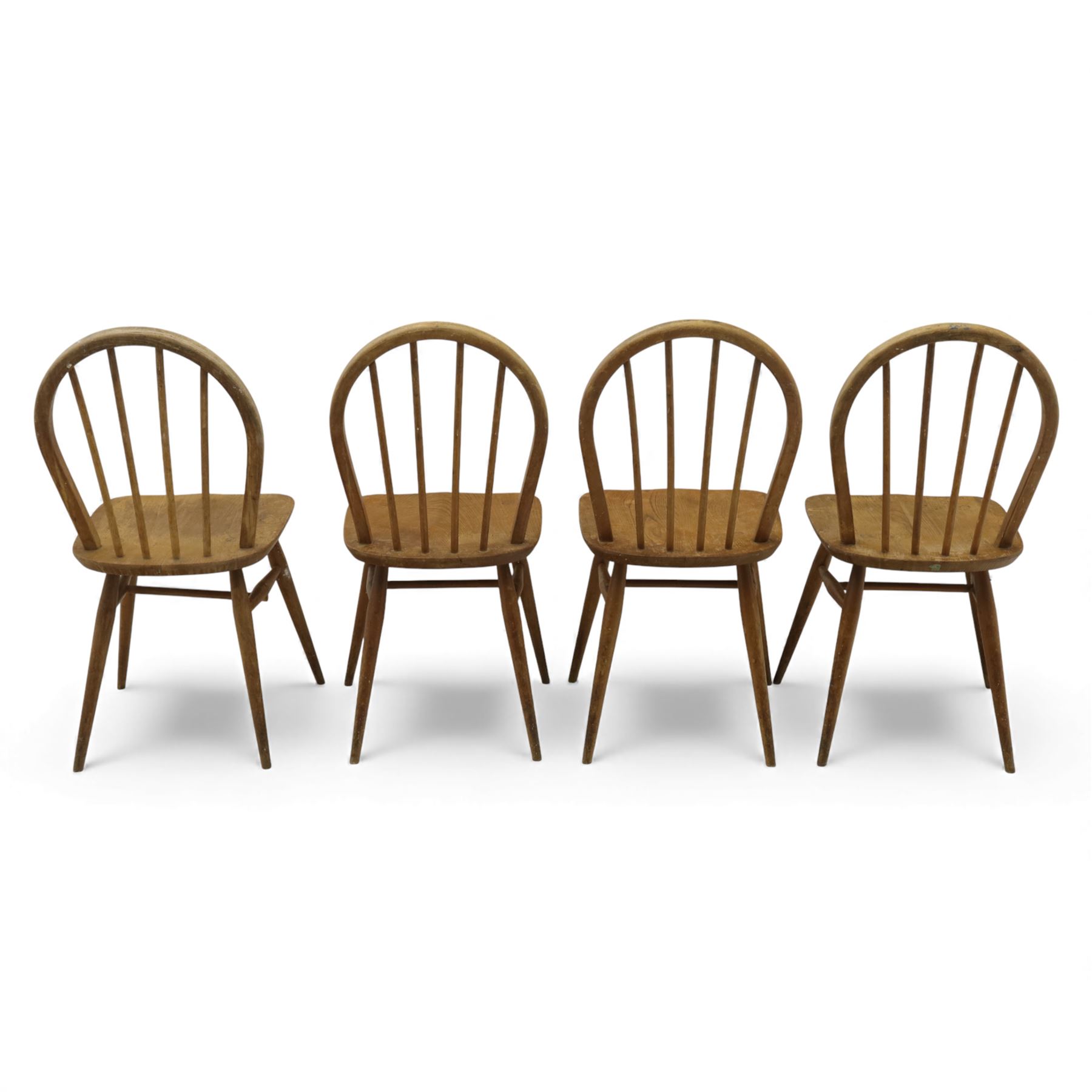 Ercol - Windsor dining chairs, set of four, each with rounded hoop back and four stick spindles, shaped elm seats with exposed plugs, raised on splayed beech tapering legs