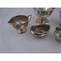 Late Victorian silver milk jug and sugar bowl, with repousse embossed floral and foliate decoration, hallmarked M Bros, Birmingham 1900, together with an early 20th century sugar caster, of typical waisted form, the pierced cover with urn finial, hallmarked Charles Boyton & Son Ltd, London 1918, and a pair of navette shaped open salts, with fluted embossed decoration, hallmarked J & R Griffin Ltd, Chester 1914, caster H17cm