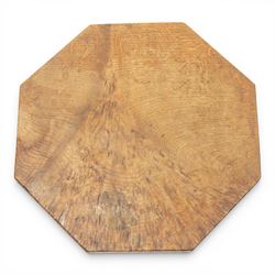 Mouseman - early 20th century adzed and figured burr oak coffee table of small proportions, the octagonal lightly adzed burr top raised on cruciform base and sledge feet, carved with tall mouse signature, by the workshop of Robert Thompson of Kilburn 