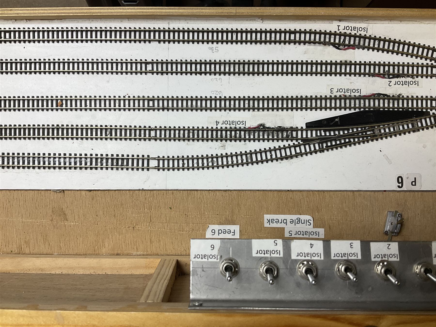 'Z' gauge continental scenic layout with folding legs, various loops of track and sidings with overhead cables, buildings including water tower, tunnels, roads with motor vehicles and figures, trees, haven with boats, backdrop diving wall hiding control units 150 x 50cm