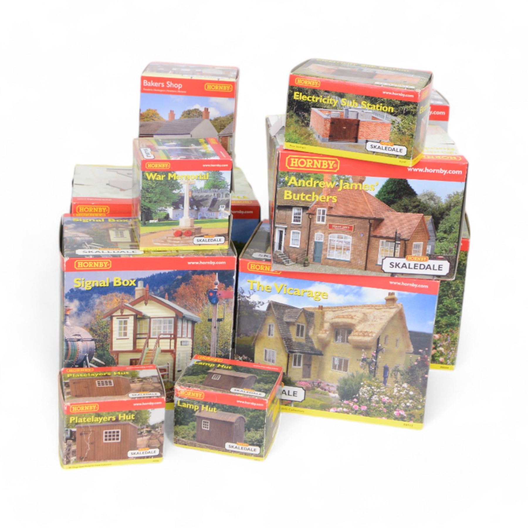 Eleven Hornby '00' gauge Skaledale buildings, comprising R9771 Three Barrels Wine Bar, R8534 Signal Box, R8747 Electricity Sub Station, R8585 Lamp Hut, R8586 Platelayers Hut, R8575 War Memorial, R9828 Bakers Shop, R9767 Andrew James Butchers, R8504 Holly Farm Cottages, R8566 The Boar's Head and R8513 The Vicarige, all boxed