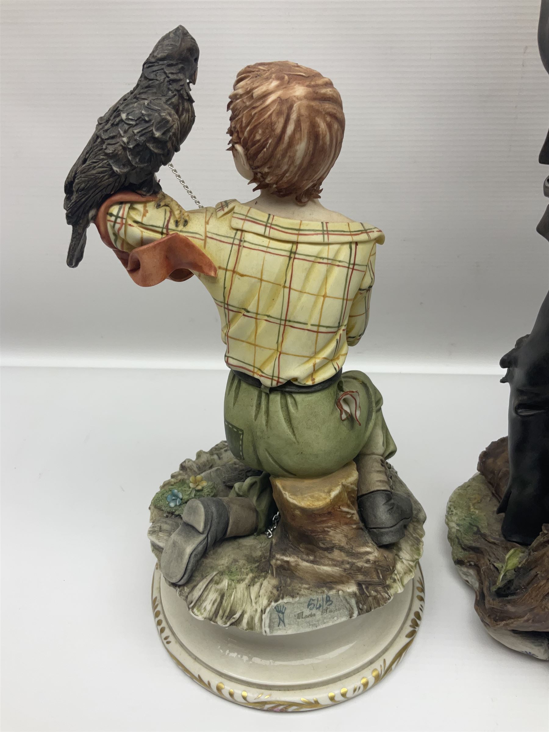Three Capodimonte figures, to include The Kind Heart Man, modelled by Cortese as a tramp with two doves, The Young Falconer by Maria Angela and another modelled as a tramp darning his socks, all with printed marks, tallest H39cm