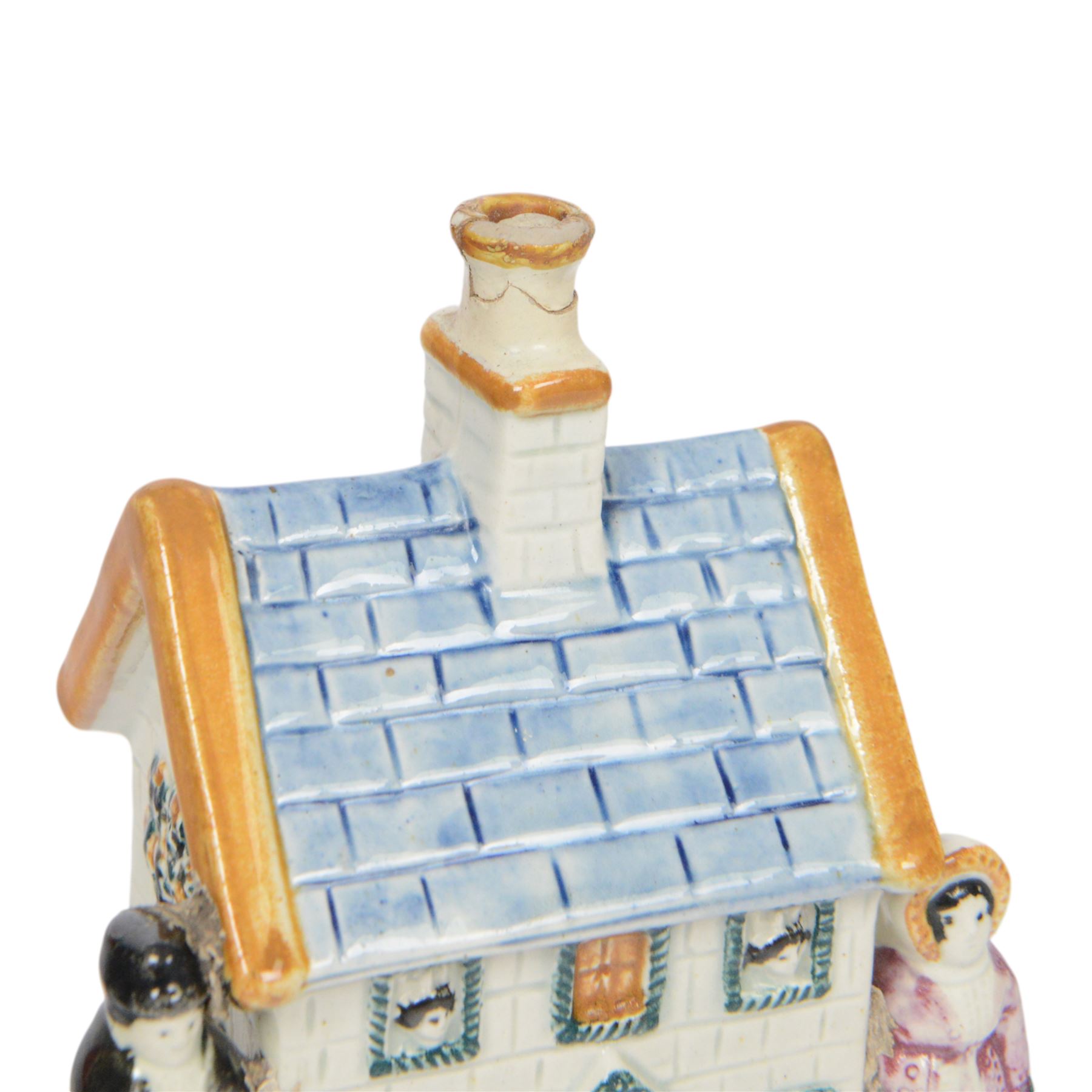 19th Century Staffordshire pearlware Prattware type money box, modelled as a houe with two figures to the front corners, H13cm