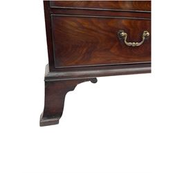 George III mahogany linen press, moulded projecting cornice over two figured doors, the interior fitted with four linen slides, the lower section fitted with two short and two long drawers, on splayed bracket feet 