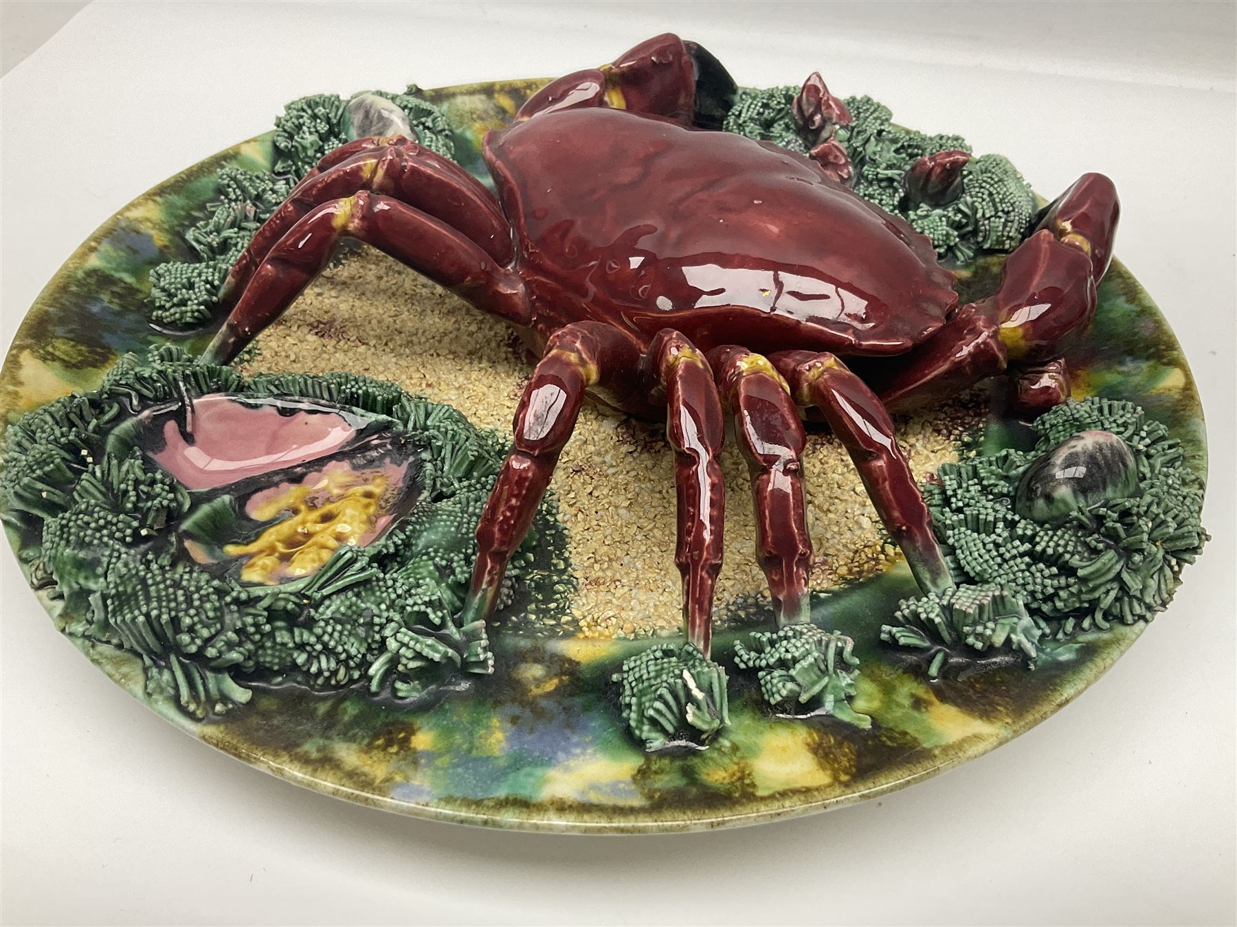 Two 20th Century Portuguese Palissy style Majolica wall plates, one depicting a crab, the other a lobster each to the centre modelled in relief surrounded by encrustations and shells, both with impress marks beneath, D34cm