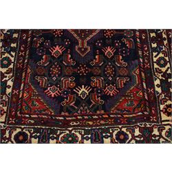 North West Persian Malayer hand-knotted runner, indigo field with vertical lozenge medallions surrounded by angular floral sprays, rosettes, and stylized palmettes, field enclosed by serrated ivory spandrels incorporating polychrome floral decoration, framed by ivory ground main border of stylized flowers and hooked devices, flanked by reciprocal guard stripes, cotton fringe ends 