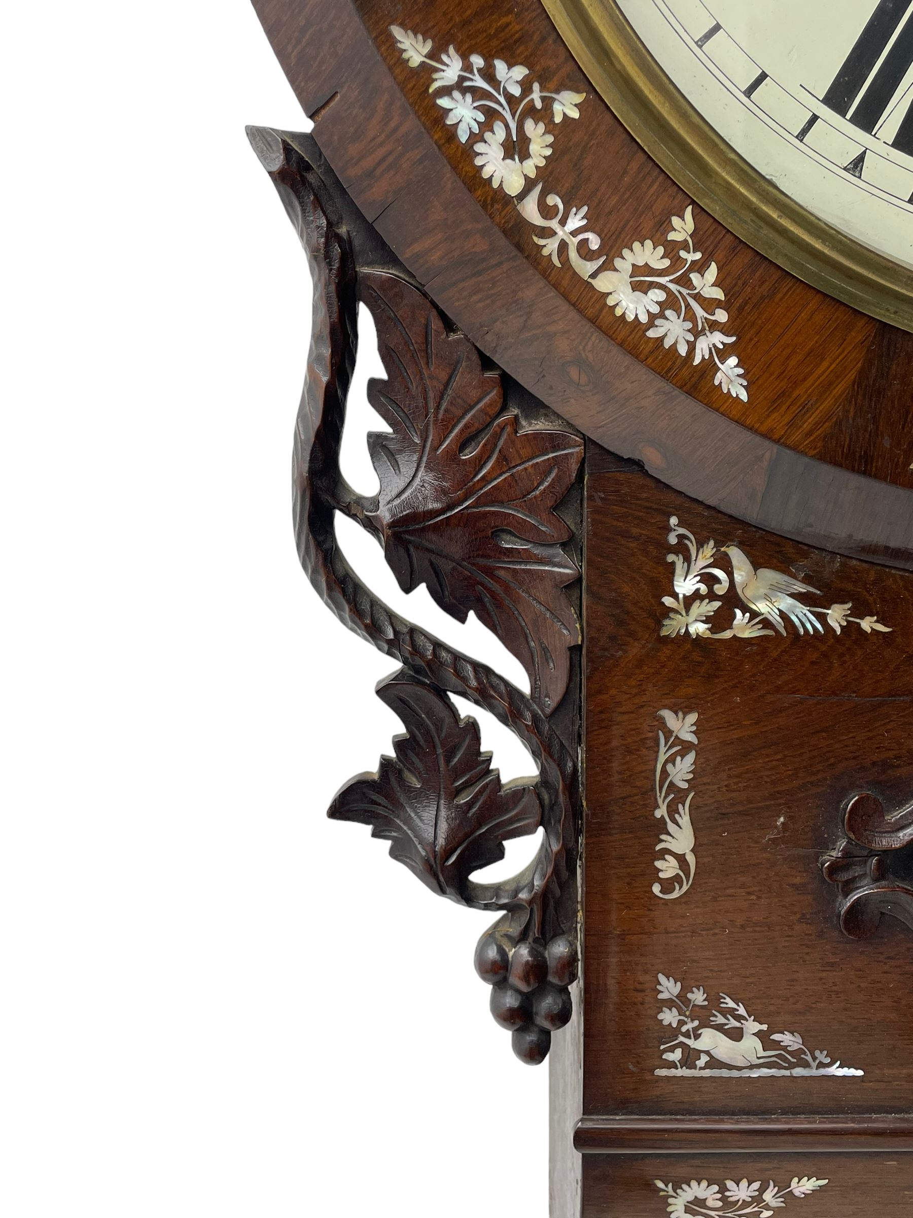 Joseph Critchley of Liverpool -  early 19th century twin fusee 8-day rosewood and mother of pearl inlaid drop-dial wall clock c1820, inlaid circular wooden dial surround with carved ears representing grapes and vine leaves, glazed box with a scroll carved surround, curved base and pendulum adjustment door, 14” painted dial with Roman numerals, minute track, and pierced steel hands within a cast brass bezel and flat glass, dial pinned to a four pillar chain driven fusee movement striking the hours on a bell. With pendulum and key.