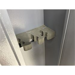 Grey steel wall mounting gun cabinet to accommodate three guns; single door with two locks with two keys for one lock; internally H128.5cm W21cm D17.5cm; externally H129cm W21.5cm D20cm