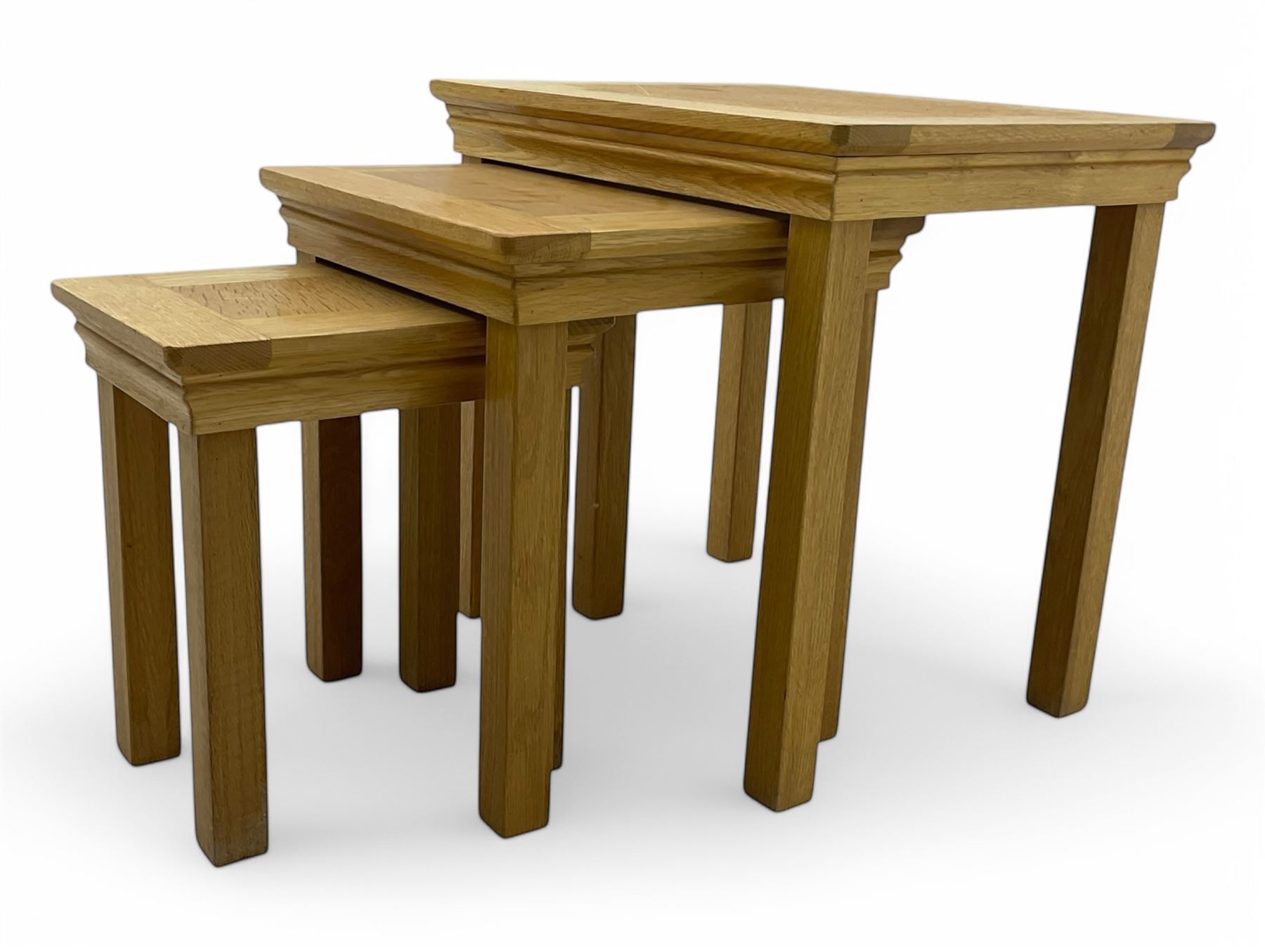 Contemporary light oak nest of three tables, each with rectangular top with moulded edge, raised on square supports