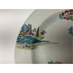 Three 18th century Chinese Famille Rose plates, the first example enamelled with blossoming peonies, rockwork and fence, the other two examples of similar design, decorated with blossoming peonies and sprigs within shaped inner borders, each approximately D23cm