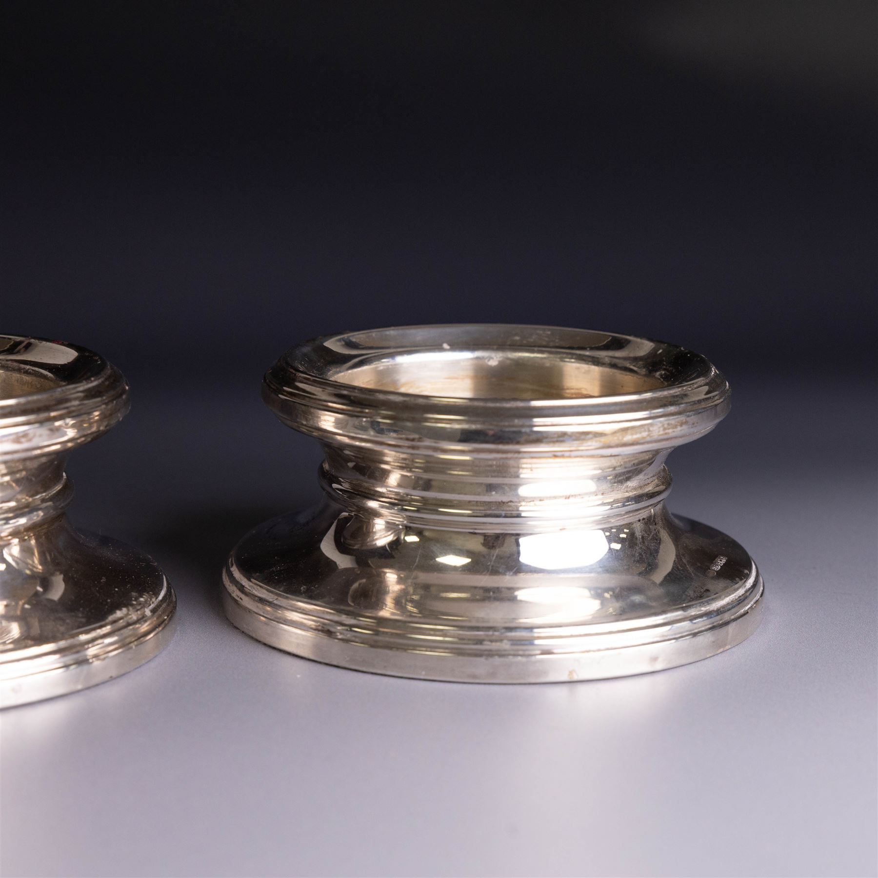 Pair of modern silver mounted candle holders, of circular stepped form, hallmarked Broadway & Co, Birmingham 2006, H5.5cm, D11cm
