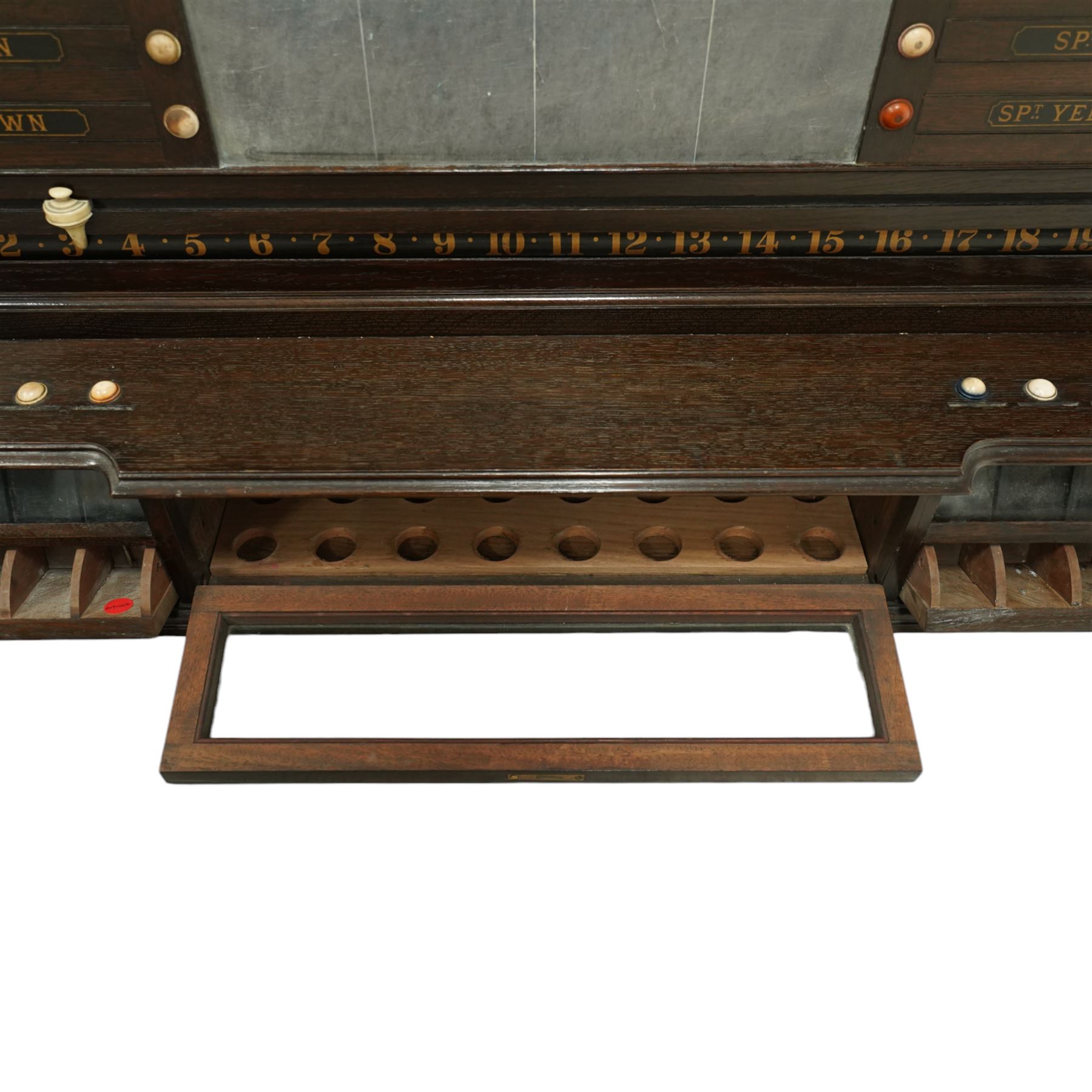 Victorian wall-mounted oak and walnut cased scoreboard,  moulded top, with a name stencilled in the frieze ‘J. Ashcroft, Victoria Street, Liverpool’, the board with chalk panel in the centre for recording scores, sliding panels on both sides for the various games of Billiards and Snooker, two numbered rotating arms with adjustable sliding score keepers, the base section with 5 apertures on each side, and coloured ivory roundels, all with glass front for viewing the tokens inside, with drawers beneath, the centre has a long glass panel for storing billiard balls, circa 1870 This item has been registered for sale under section 10 of the APHA Ivory Act Reference UNEGEBLB
