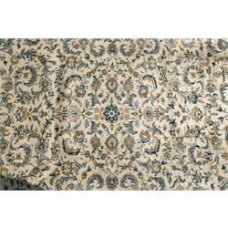 Central Persian Kashan hand-knotted carpet, ivory field profusely decorated with an all-over scrolling vine, palmette, and lotus design in shades of soft blue, pale gold, and green within floral borders