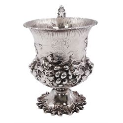 William IV silver christening mug, of campana form, the body repousse decorated with fruiting vines, engraved with crest and quote 'God is our strength', with leaf capped scroll handle, upon spreading vine leaf foot, hallmarked Charles Fox, London 1837