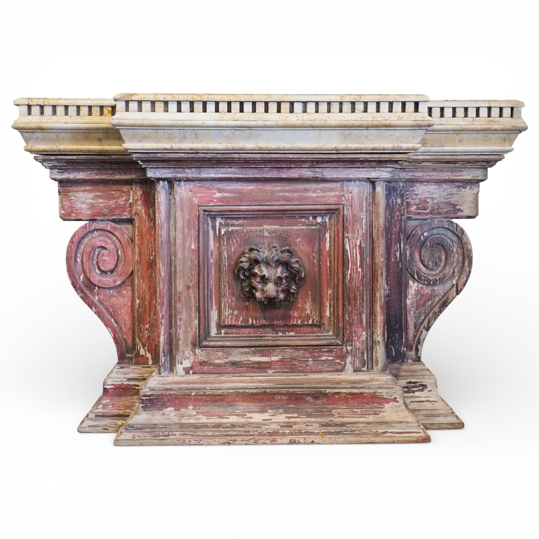 A 20th century Italian Neoclassical console table of monumental architectural form, inspired by Roman altar and sarcophagus prototypes; the rectangular marble top with dentil-moulded edge and polychrome geometric compass-star inlay, executed in contrasting marbles on a dark green ground, above a pedestal base of simulated stone finished in red porphyry-type tones, centred by a lion’s mask in relief and flanked by Ionic scroll volutes, raised on a stepped plinth base
