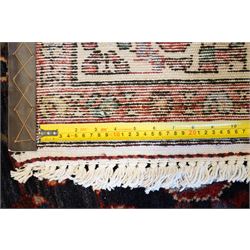 North West Persian Hamadan hand-knotted runner, indigo field with an all-over herati inspired lattice issuing from a central axis with stylized palmettes, rosettes and angular vinery, enclosed by stepped triangular spandrels with ivory reserves, broad ivory main border of stylized flowers and geometric devices, flanked by reciprocal guard stripes, cotton fringe ends 