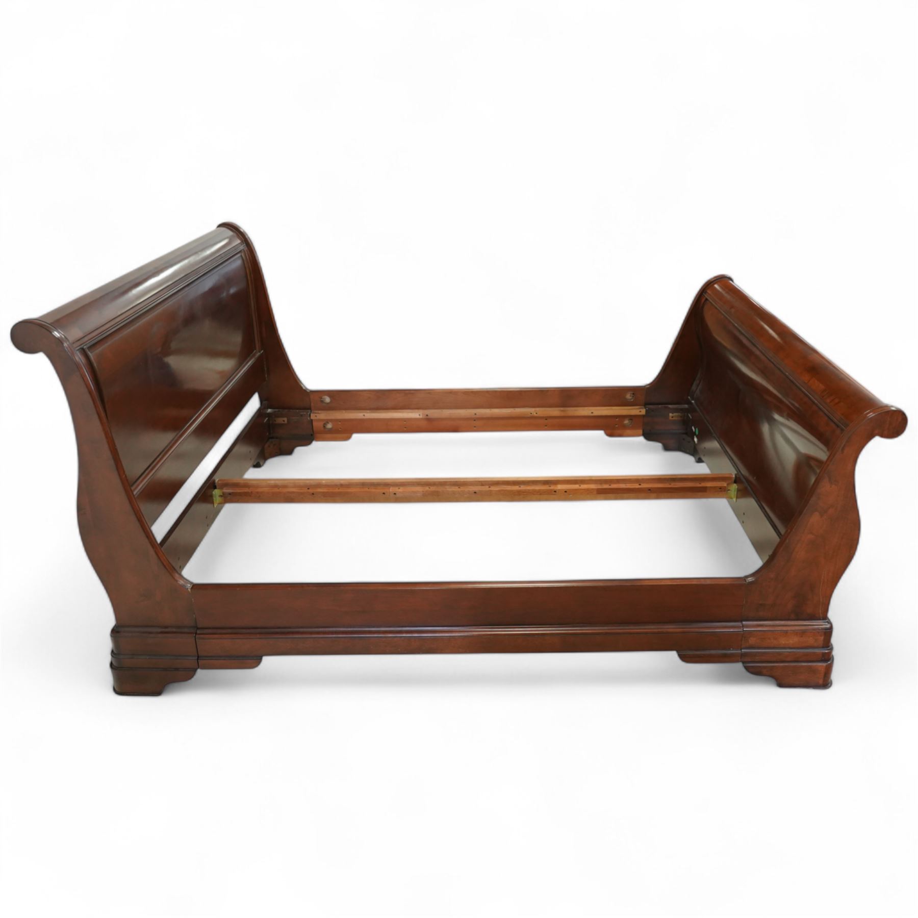 Late 20th-century mahogany Empire-style double sleigh bed, scrolled panelled headboard, and footboard, base with moulded plinth raised on bracket feet