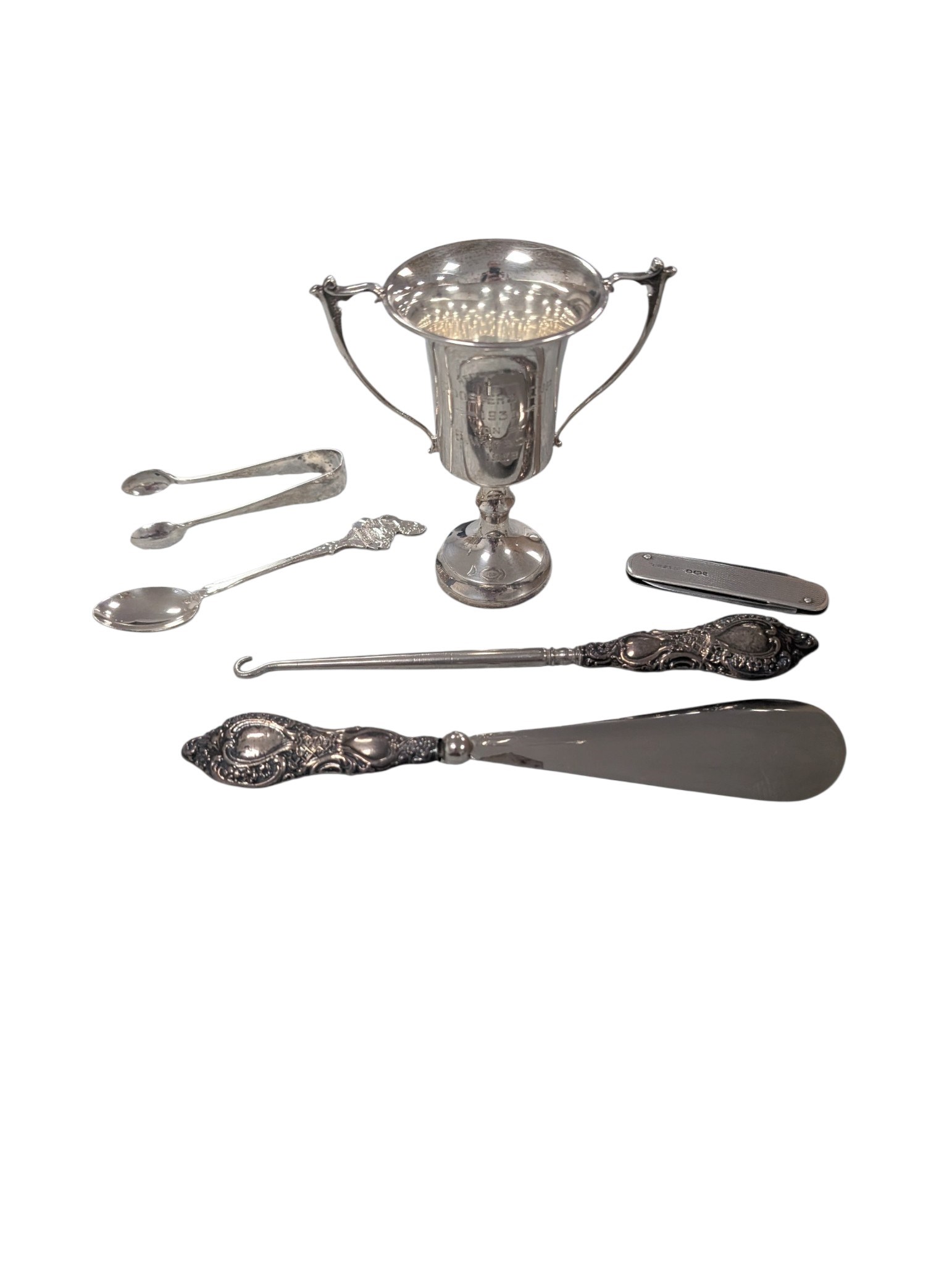 Small collection of silver comprising trophy, fruit knife, spoon, sugar tongs and silver handled hook and shoe horn, together with a silverplated epergne and other metalware