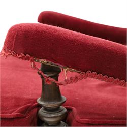 Victorian walnut framed reading open armchair of reclined position, the high sprung back and deep seat upholstered in crimson fabric with matching loose seat cushion, turned arm terminals over turned feet terminating to brass castors