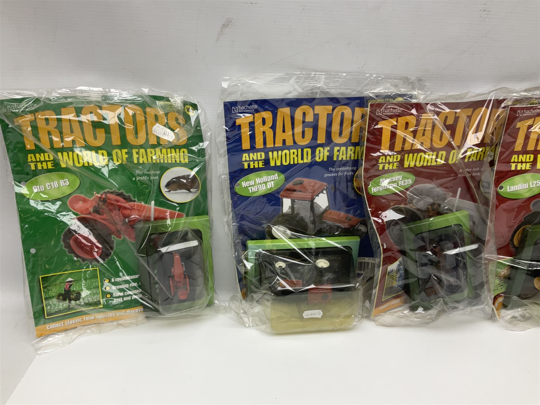 Eighteen issues of Tractors and The World of Farming magazine, together with sixty diecast tractors, all in original packaging, in three boxes 