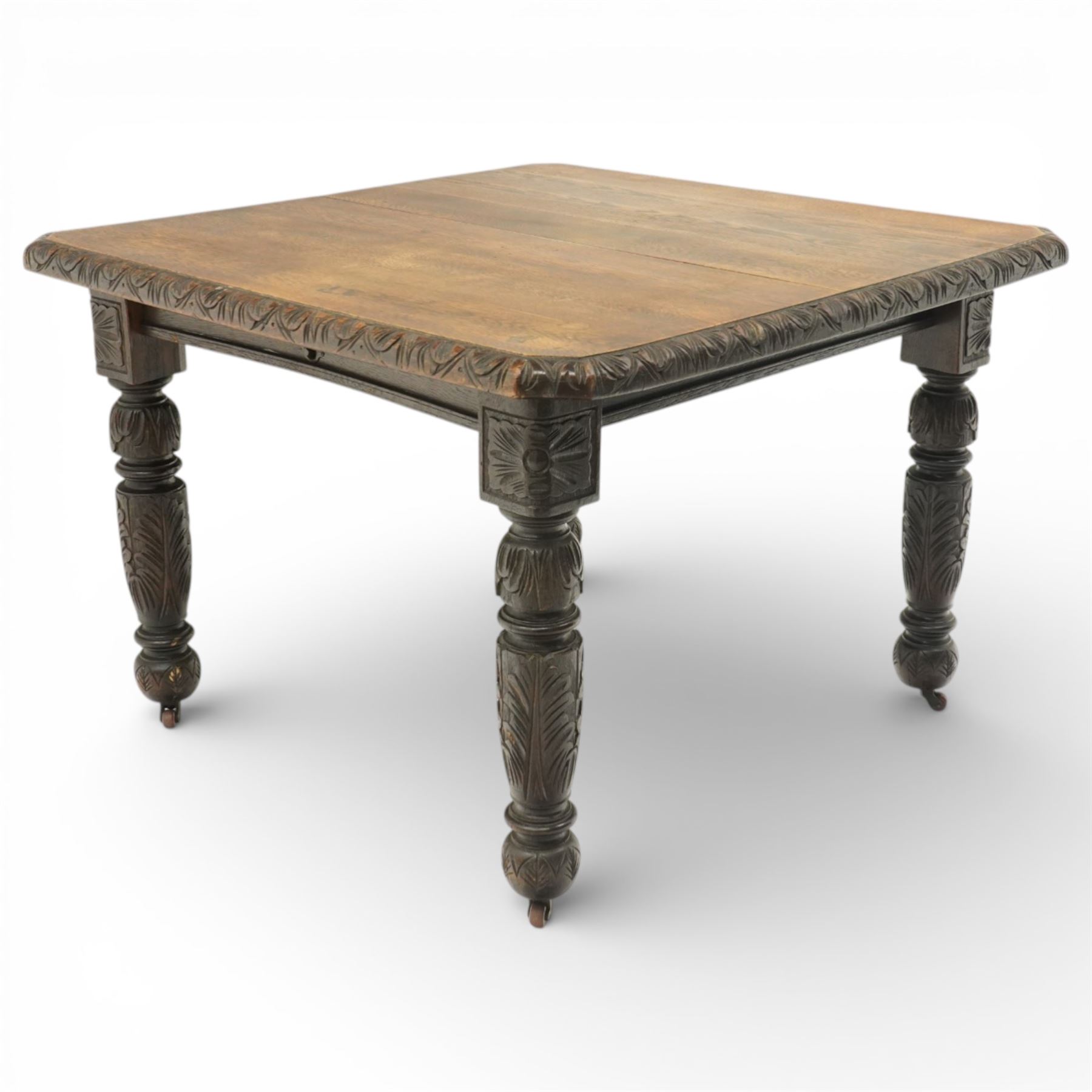 19th century heavily carved oak extending dining table, with winding mechanism and a gadrooned edge, over block and turned supports terminating in castors, extends to 147cm
