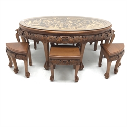 Eastern glass topped oval table decorated in high relief with six integral stools, W124cm, H50cm, D80cm