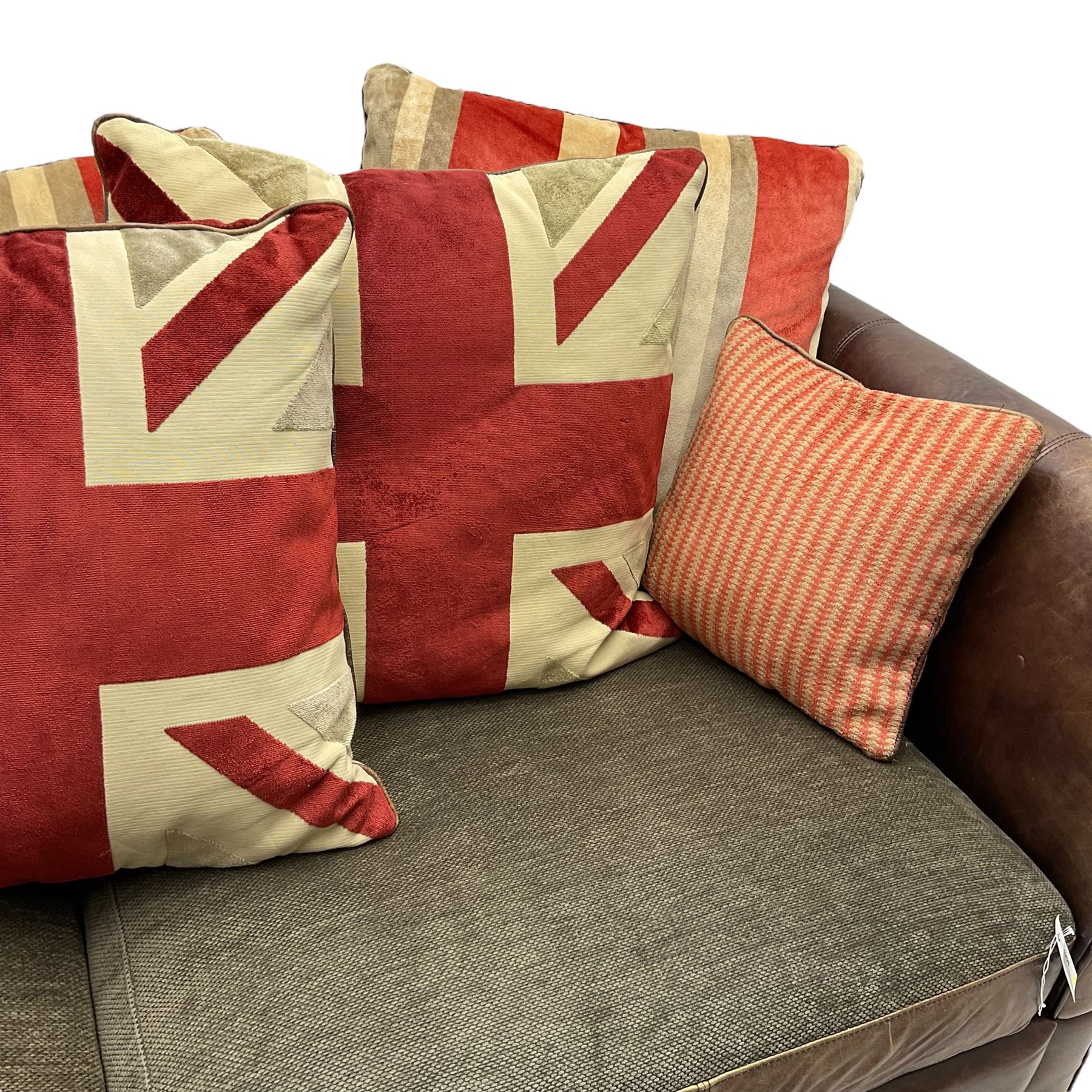 Large Knole design three-seat sofa upholstered in brown leather with scatter cushions upholstered in contrasting striped and Union Jack patterned fabric, on block feet (W210cm, H100cm, D102cm); together with matching rectangular footstool (135cm x 75cm, H45cm)