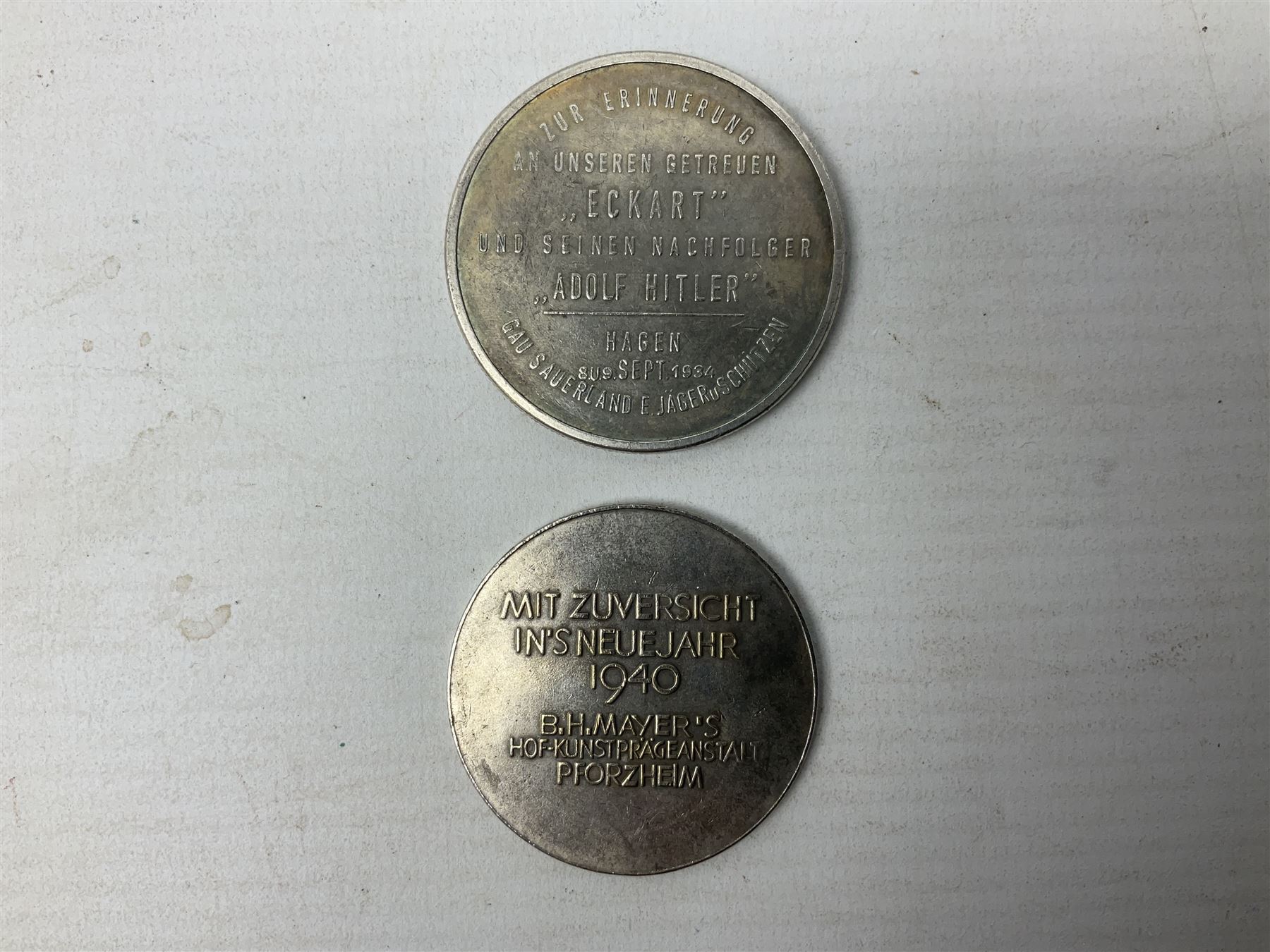 Four post-WW2 'silver' medallions of Adolf Hitler/German interest, two depicting Von Hindenburg also; and pair of 1960s trench art shell case bases as ashtrays mounted with Libyan Five Milliemes coins as cigarette rests (6)
