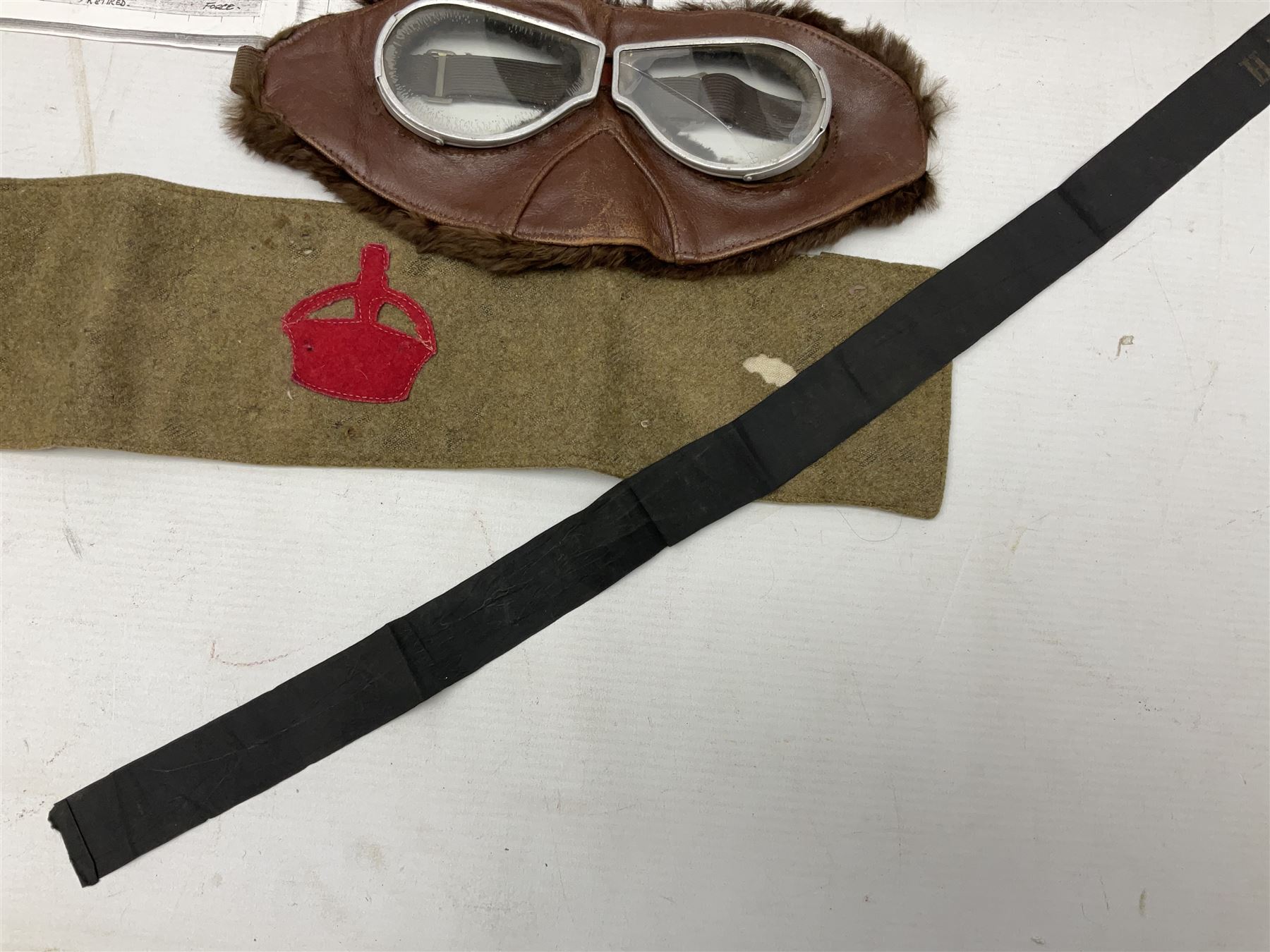 WW1 British Army Derby Scheme 1915 Attested armband; beret with East Yorkshire cap badge; pair of fur lined leather flying/motorcycle goggles; HMS Pembroke cap band; and small quantity of RNAS cloth and metal badges etc