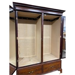 George III mahogany double wardrobe, the projecting cornice with dentil moulding over two panelled doors with mirror-lined interiors, enclosing hanging rails and brass hooks, the base fitted with two drawers, raised on bracket feet