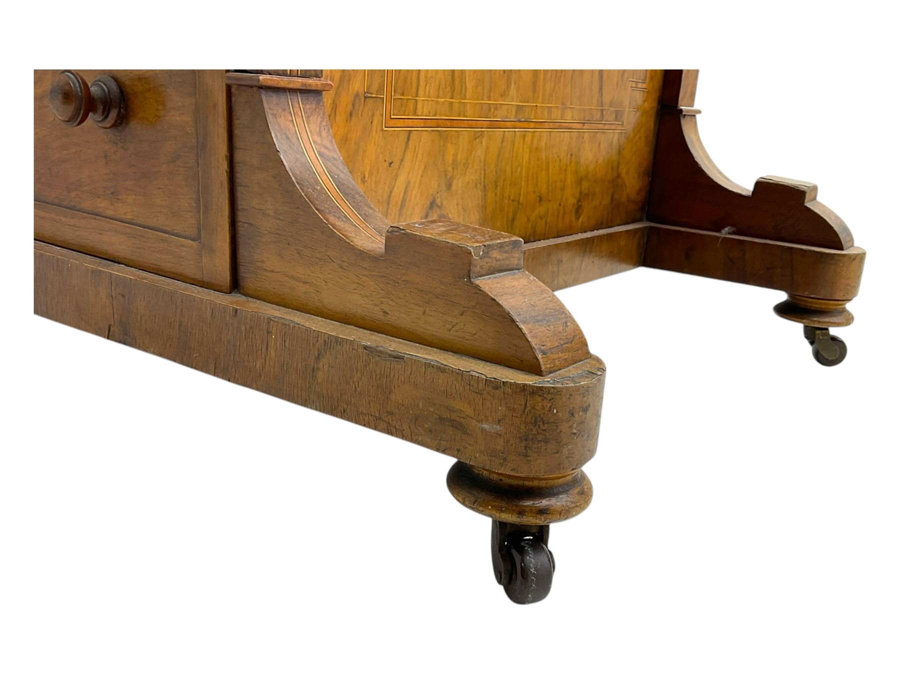 Early 19th century burr walnut Davenport desk, sloped leather-inset writing surface with brass gallery, fitted with an inkwell compartment and pen slot, four drawers to one side, raised on scrolled supports terminating in castors
