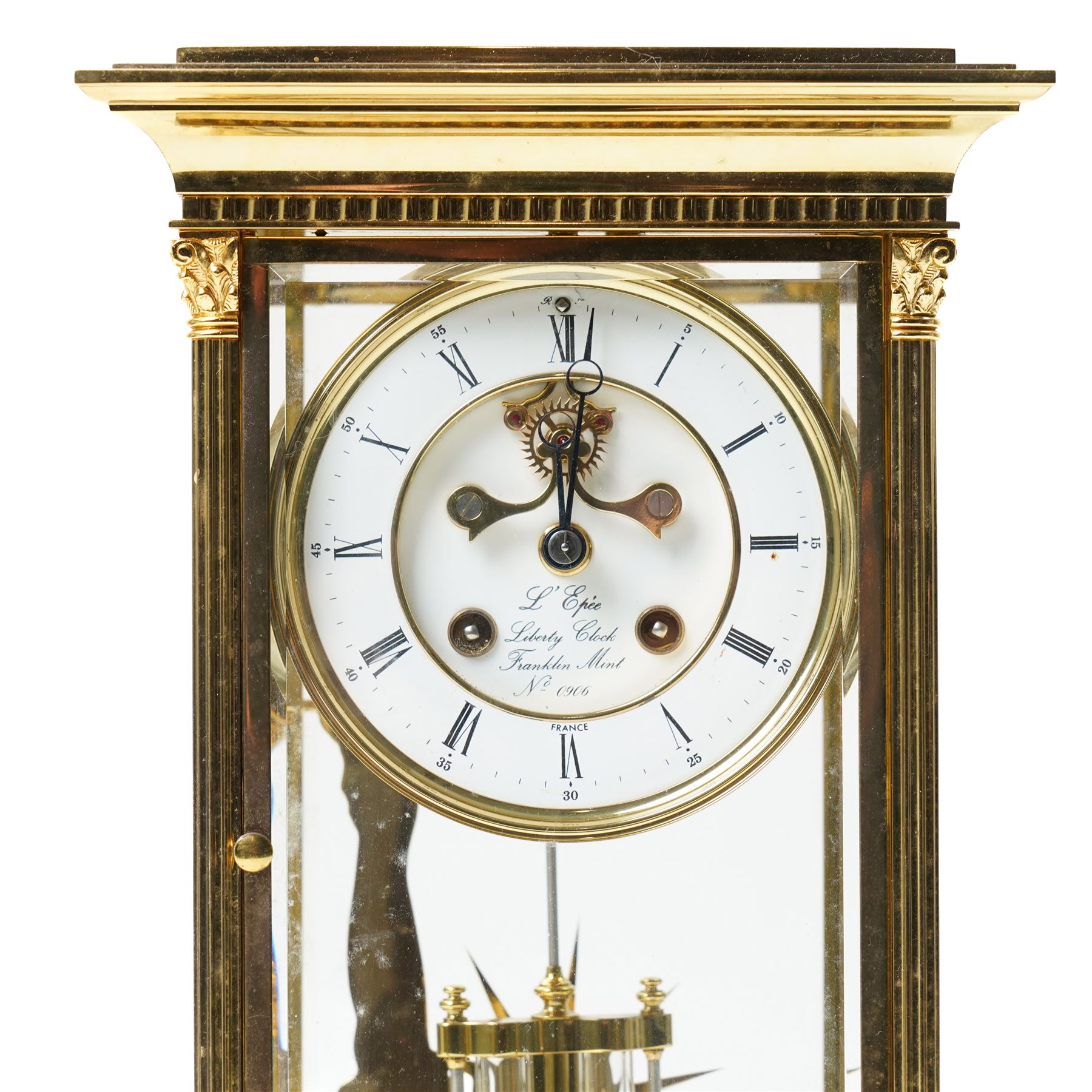 American-20th century Franklin Mint  8-day four-glass mantle clock, brass case with bevelled glass to the doors and sides, with reeded columns and Corinthian capitals to the corners, enamel dial with Roman numerals and five minute Arabic's, with steel moon hands and visible jewelled Brocot escapement, Dial inscribed L' Epee, Liberty Clock, Franklin Mint. No 0906 , with a twin file mercury pendulum and brass silhouette depiction of the Statue of Liberty to the rear of the case, twin train going barrel movement with rack striking.