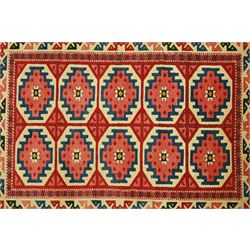 Anatolian Soumak rug, ivory ground decorated with a grid of eight octagonal medallions in terracotta red outlined in blue, centered with a star motif in vertical rows, framed by a series of geometric borders in ivory, green, and blue, incorporating hooked devices and stylized lozenges and stripped end panels, with signature at either end 