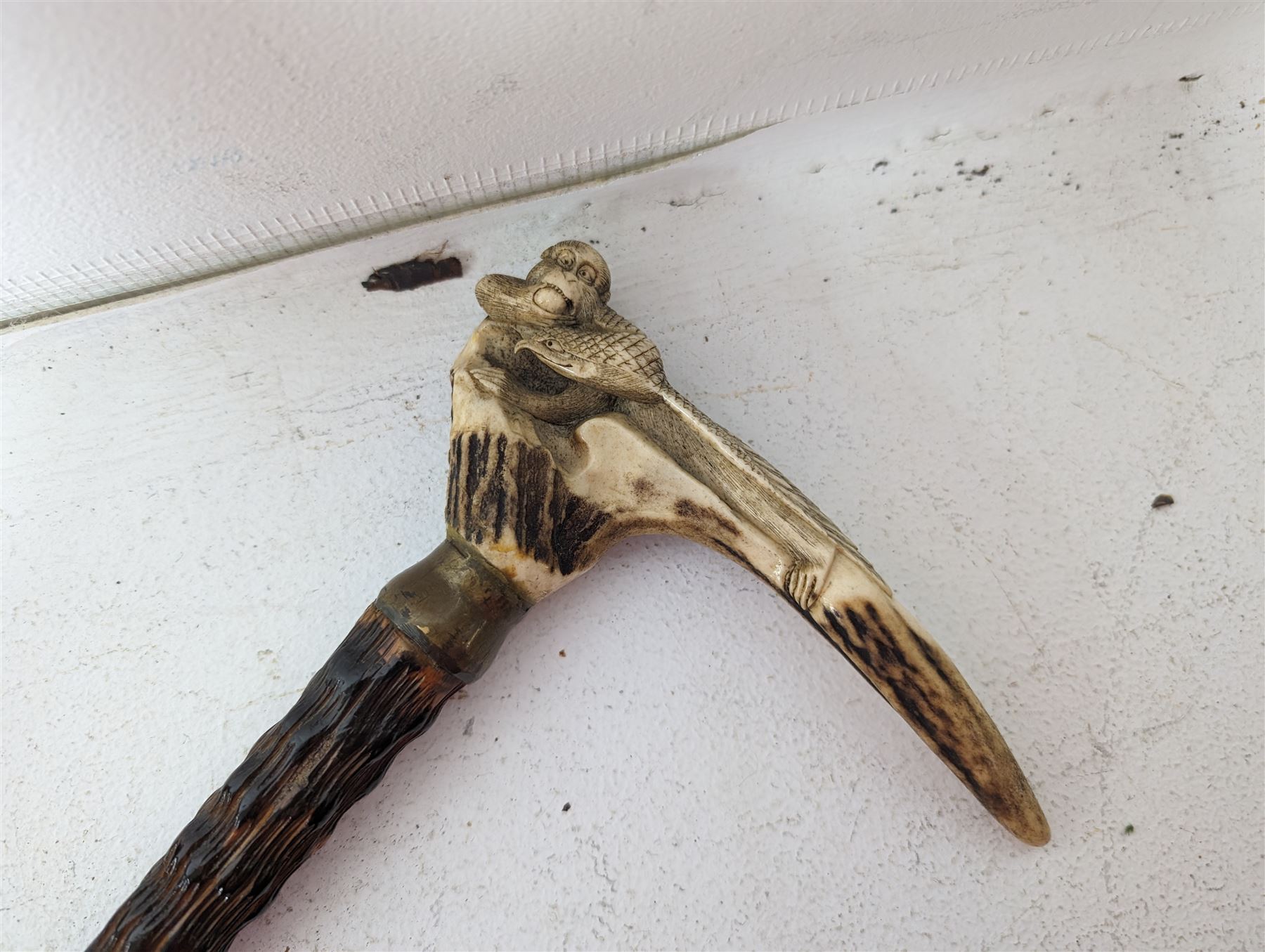 Walking stick with carved monkey handle, glass shooting flask in the form of a cartridge, bullet casings and other collectables