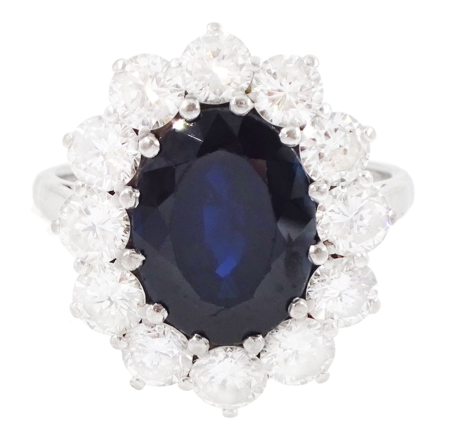 18ct white gold sapphire and diamond cluster ring, single oval cut sapphire of approx 4.50 carat, surrounded by twelve brilliant cut diamonds, Birmingham 1982, total diamond weight approx 2.65 carat