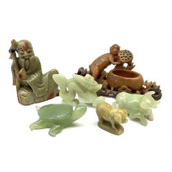 A Chinese carved jade model of a water buffalo, L6cm, together with a tortoise, dragon, and three soapstone models, the first example carved as a sage, the second example as a money with open 'pot', and the third example as a pig. (6). 