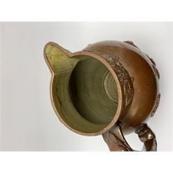 19th century salt glazed stoneware jug, with mask spout and greyhound modelled handle, the body decorated in relief with Royal Coat of Arms flanked by lions, the rim with the flowers of the union, roses, thistles and shamrocks, H26.5cm