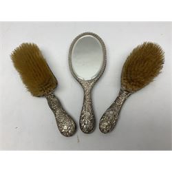 Three piece silver mounted dressing table set, comprising hand held mirror, hair brush, and clothes brush, all hallmarked 