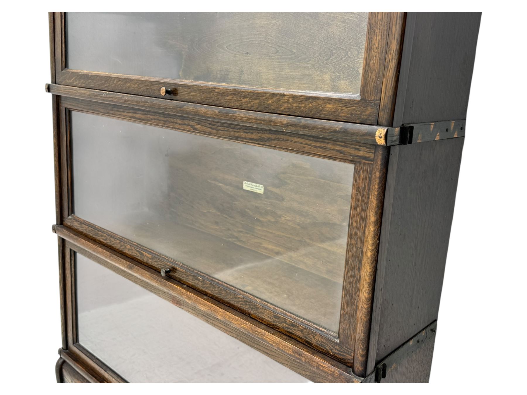 Globe Wernicke - stacking sectional library bookcase, over four glazed up-and-over doors, each bearing original makers mark, on moulded plinth base with inbuilt drawer
