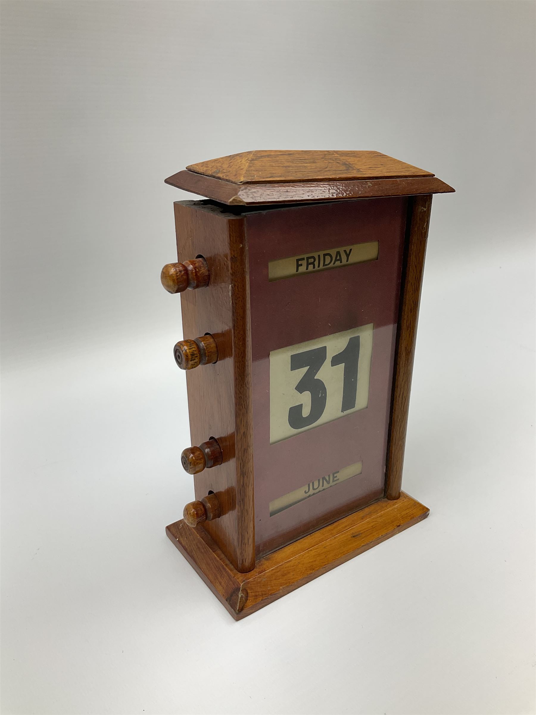 An early 20th century oak perpetual desk calendar, with three glazed apertures for day, date and month, H20cm