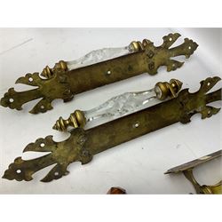 Pair of brass door handles with stylised fleur-de-lis motifs and cut glass handles, together with another similar smaller and two door knobs, largest L46cm