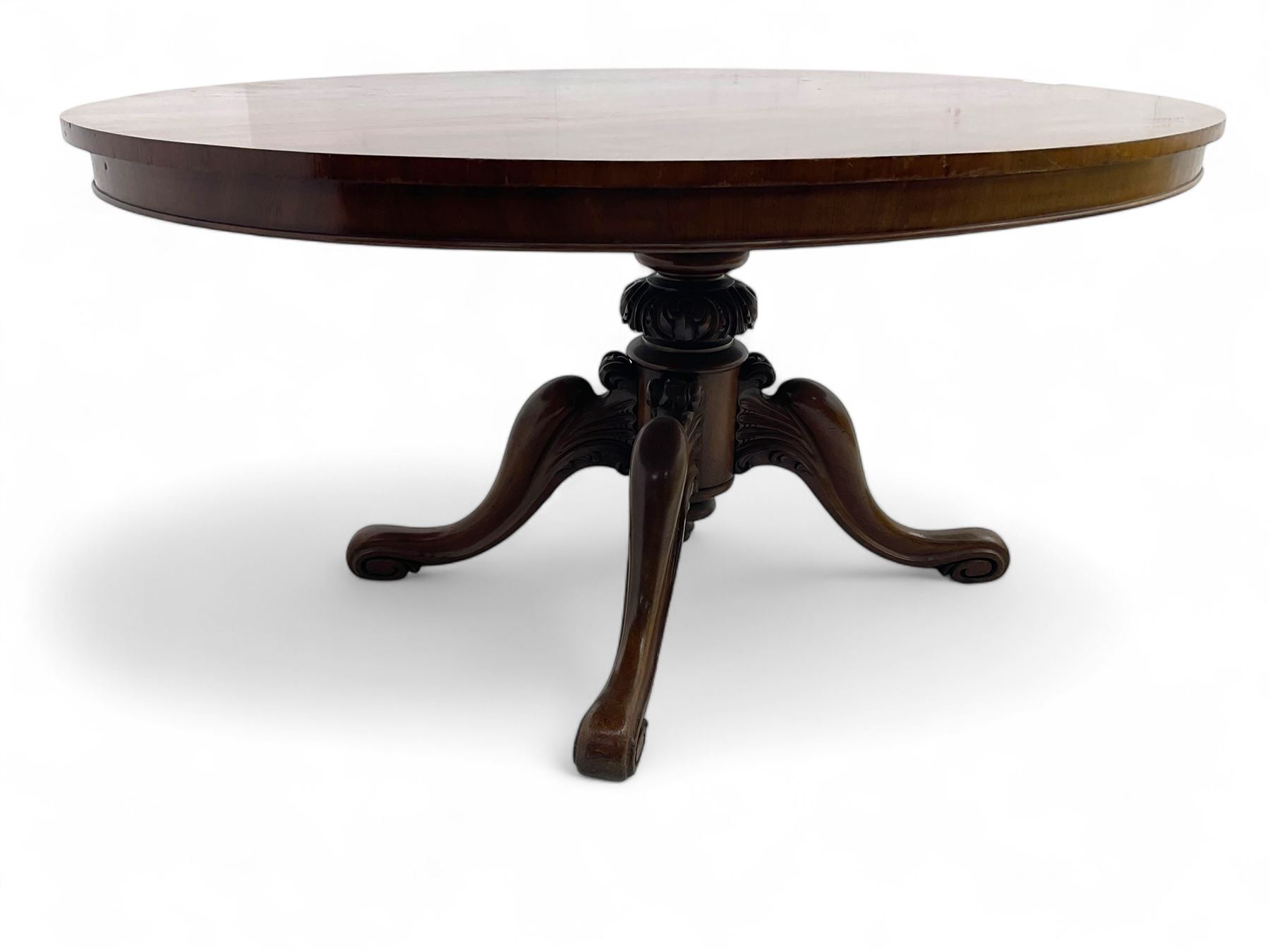Victorian mahogany breakfast loo table, oval tilt-top on turned pedestal, quatrefoil out-splayed carved supports, scroll carved terminals with brass castors