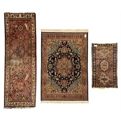 Belgian Sultan woollen ground rug, central navy field densely decorated with floral sprays and geometric patterns (192cm x 135cm); handwoven tribal terracotta ground rug (121cm x 71cm); Persian crimson ground runner, all over stylised floral and foliate motifs (266cm x 94cm)